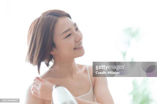 woman drying her hair with a hair dryer - asian woman short hair stock pictures, royalty-free photos & images
