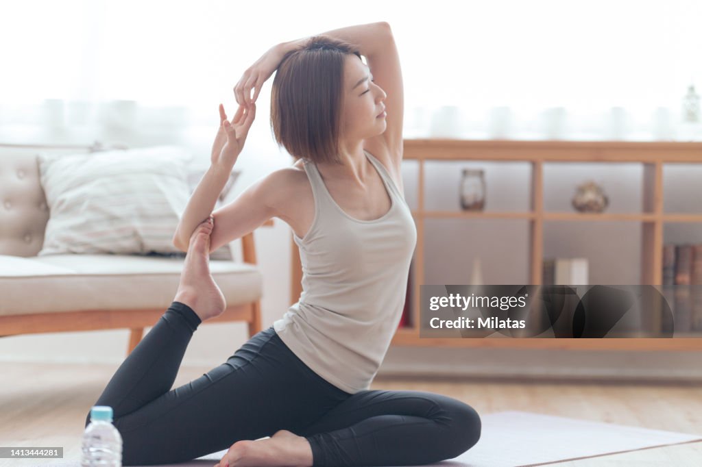 A woman stretching in her room