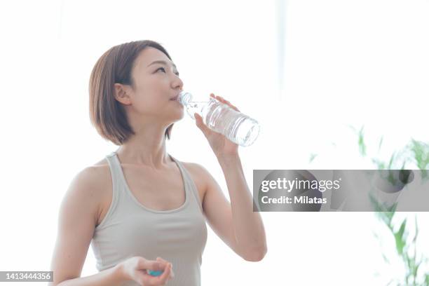 woman drinking water from a plastic bottle - 息抜き ストックフォトと画像