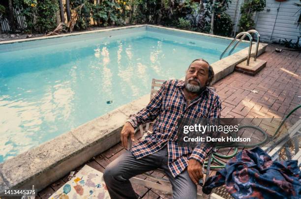 Portrait of American playwright Tennessee Williams as he sits in a deckchair beside his swimming pool, Key West, Florida, 1982.