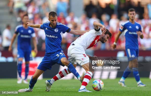 Dominick Drexler of FC Schalke 04 tackles Jonas Hector of 1.FC Koeln which later results in a red card during the Bundesliga match between 1. FC Köln...