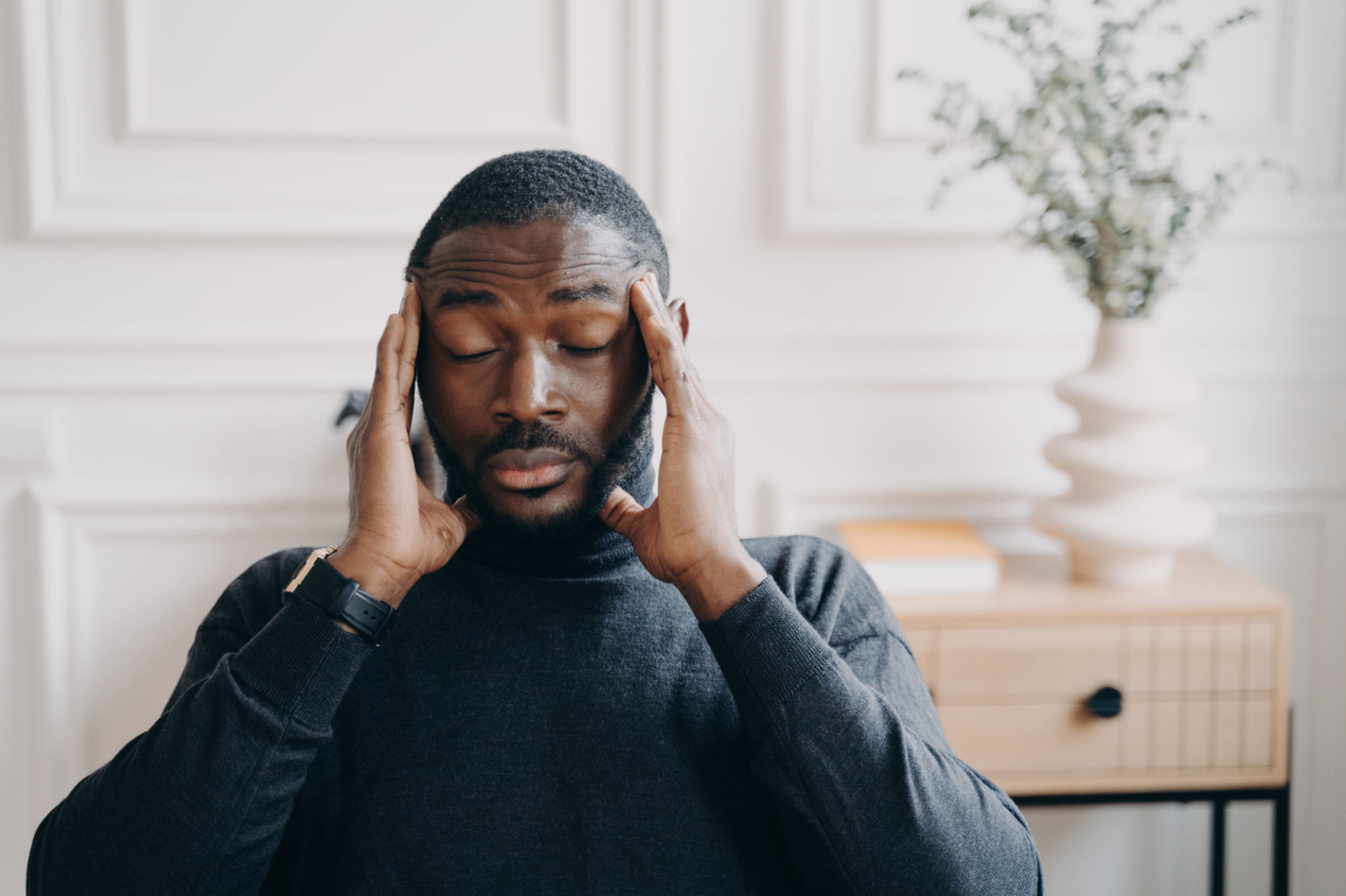 Stressed young african man employee with frustrated face expression suffering from headache Stressed young african man employee with frustrated face expression suffering from headache