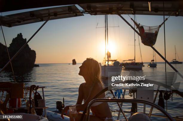 woman on a sailboat, enjoying a glass of wine at sunset - southern italy stock pictures, royalty-free photos & images