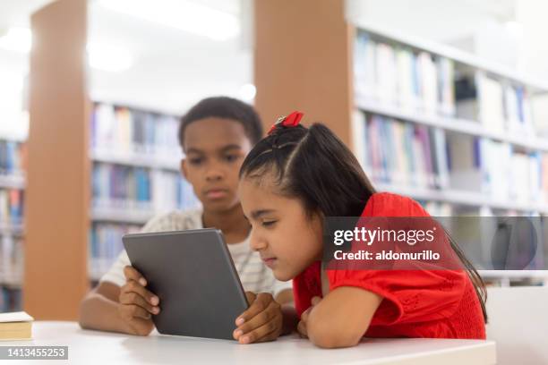 girl shortsighted looking tablet close to eyes - myopia stock pictures, royalty-free photos & images
