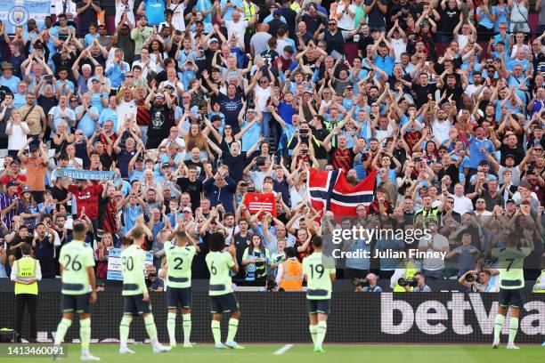 Manchester City fans celebrate after the Premier League match between West Ham United and Manchester City at London Stadium on August 07, 2022 in...