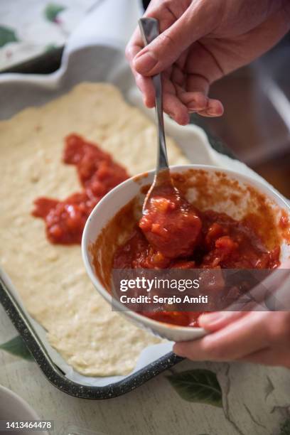 spooning chopped tomato sauce on pizza base - dipping sauce stock pictures, royalty-free photos & images
