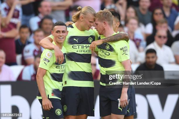 Erling Haaland of Manchester City celebrates with teammates Phil Foden and Kevin De Bruyne after scoring his team's second goal during the Premier...