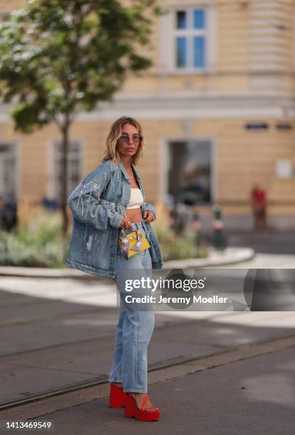 Karin Teigl wearing Zara red platform heels, Edited blue denim jeans, Lumina creme bra top, Hermes mini yellow leather Kelly bag with a matching silk...