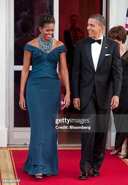 President Barack Obama, right, and first lady Michelle Obama walk to greet David Cameron, U.K. Prime minister, and his wife Samantha Cameron on the...