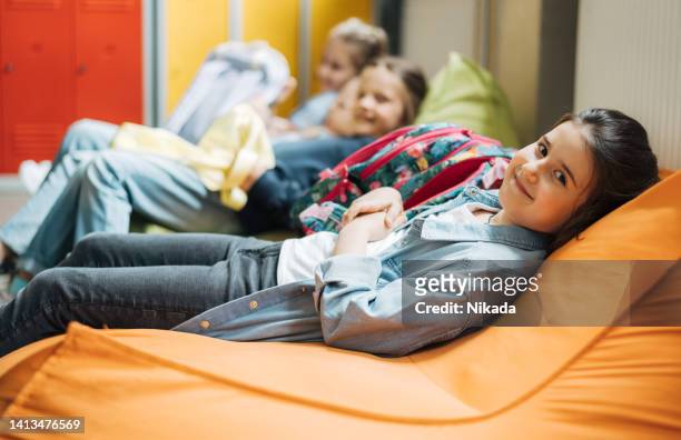 portrait d’une écolière se relaxant sur un sac de haricots - beanbag photos et images de collection