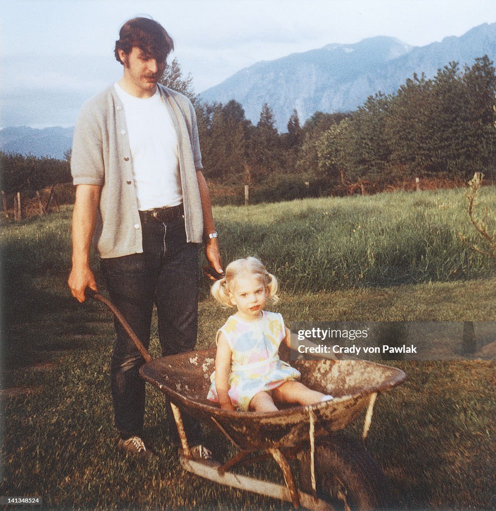 Father giving daughter wheelbarrow ride