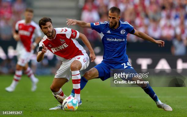 Dominick Drexler of Schalke challenges Jonas Hector of Cologne during the Bundesliga match between 1. FC Köln and FC Schalke 04 at...