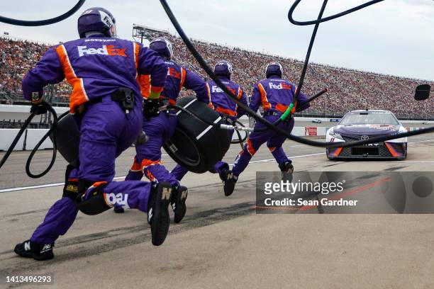 The pit crew of the FedEx Freight Toyota, driven by Denny Hamlin leap into action during the NASCAR Cup Series FireKeepers Casino 400 at Michigan...
