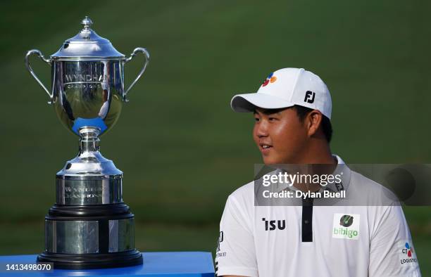 Joohyung Kim of Korea poses with the trophy after putting in to win on the 18th green during the final round of the Wyndham Championship at...