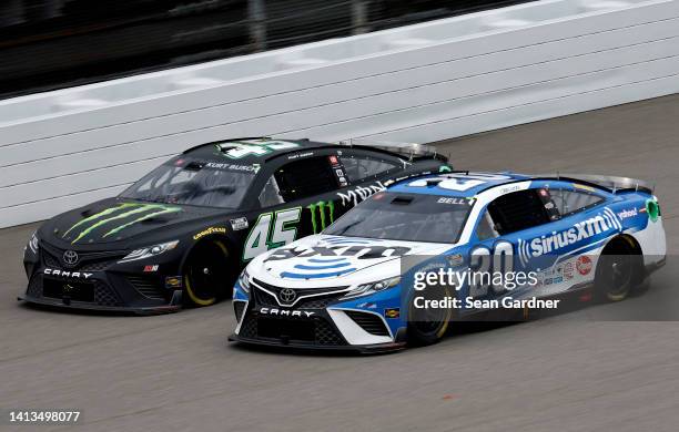 Ty Gibbs, driver of the Monster Energy Toyota, and Christopher Bell, driver of the Sirius XM Toyota, race during the NASCAR Cup Series FireKeepers...