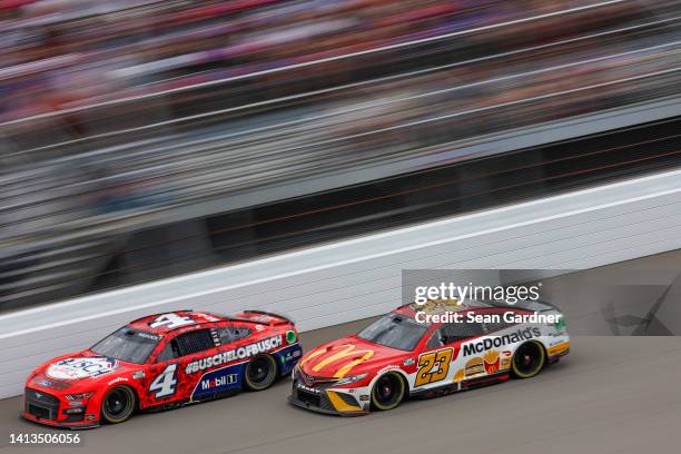Kevin Harvick, driver of the Busch Light Apple #BuschelOfBusch Ford, and Bubba Wallace, driver of the McDonald's Toyota, race during the NASCAR Cup...