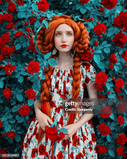 femme rousse fabuleuse. longs cheveux bouclés. peau pâle. fille avec tresses et robe fleurie sur fond rose. beau modèle aux lèvres rouges. tenue renaissance. coiffure. bijouterie et bijouterie - troll fictional character photos et images de collection