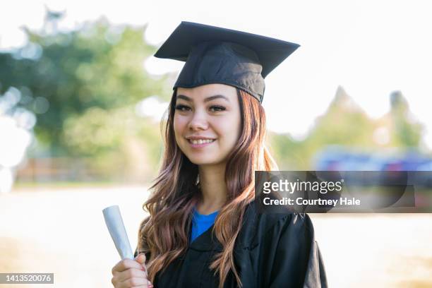 portrait of young woman wearing graduation cap and gown - scholarship award stock pictures, royalty-free photos & images