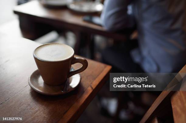 latte in a cafe with a business man in the background - manila stock pictures, royalty-free photos & images