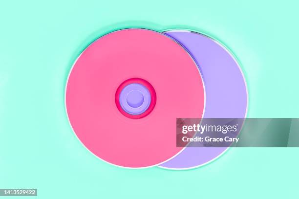 pink and purple cds on green background - rom ストックフォトと画像