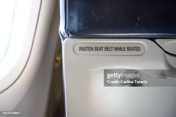 safety warning on a plane seat - sicherheitsgurt stock-fotos und bilder