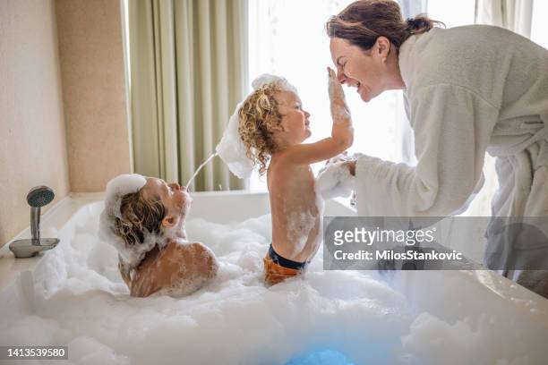 mama und jungen badezeit - kid bath mother stock-fotos und bilder
