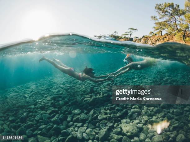brother and sister swimming underwater in sea - kid under water stock-fotos und bilder