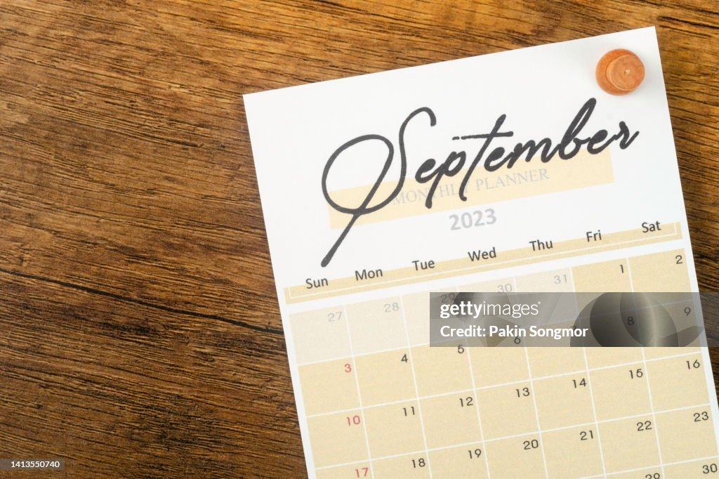 Calendar desk 2023 September is the month for the organizer to plan and deadline with a push pin on a wooden background.