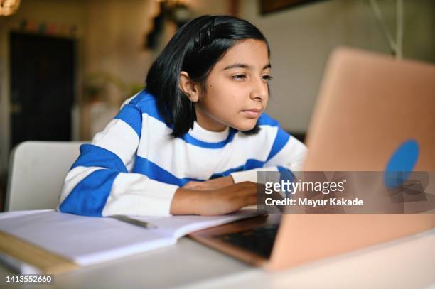 girl using a laptop and looking at it with strained eyes - entrecerrar los ojos fotografías e imágenes de stock