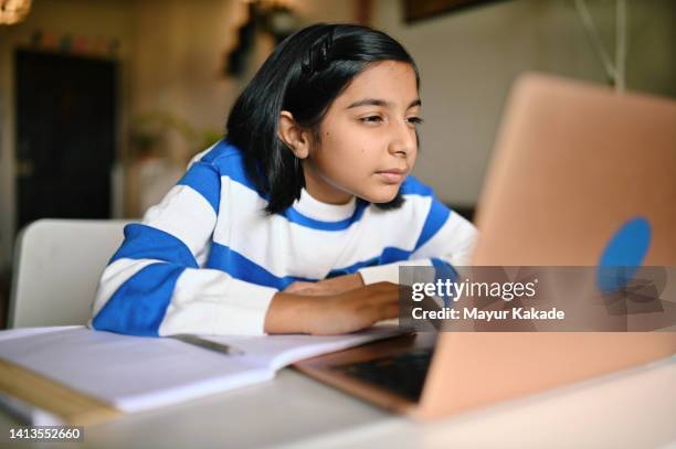 girl using a laptop and looking at it with strained eyes - cligner des yeux photos et images de collection