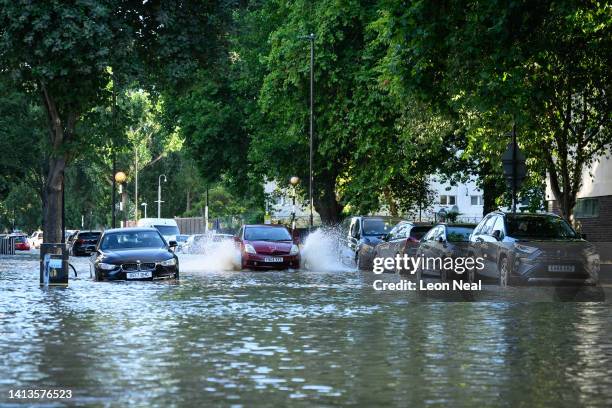 Car negotiates the substantial flooding on roads near to the Arsenal Stadium, following a rupture of water mains, on August 08, 2022 in London,...