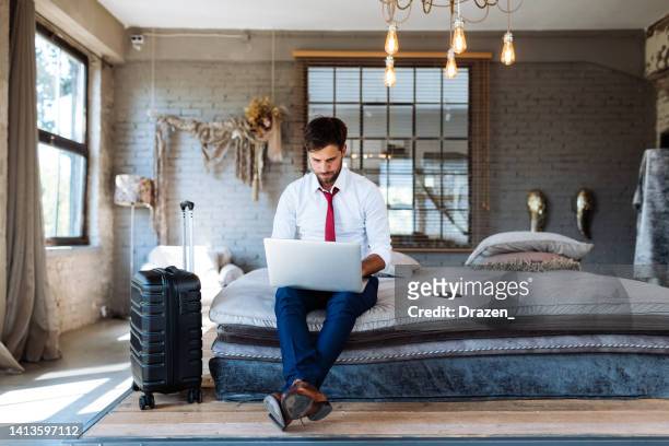 businessman working on laptop in luxury hotel room - hotel suite stock pictures, royalty-free photos & images