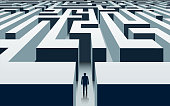 Businessman stands in front of a labyrinth.