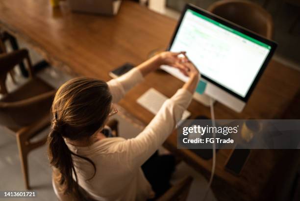 femme d’âge mûr qui s’étire tout en travaillant à la maison - fond usé photos et images de collection