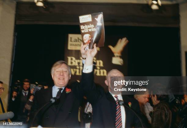 British politician Roy Hattersley, Labour Party deputy leader, British politician Neil Kinnock, Labour Party leader, jointly hold a copy of the...