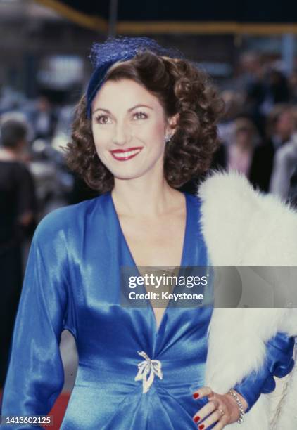 British actress Jane Seymour, wearing a blue outfit with plunging neckline and a blue fascinator, attends the London premiere of 'Octopussy,' held at...