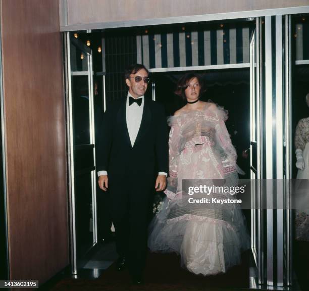 British actor and comedian Peter Sellers , wearing a tuxedo, bow tie and sunglasses, and his wife, British socialite and fashion model Miranda Quarry...