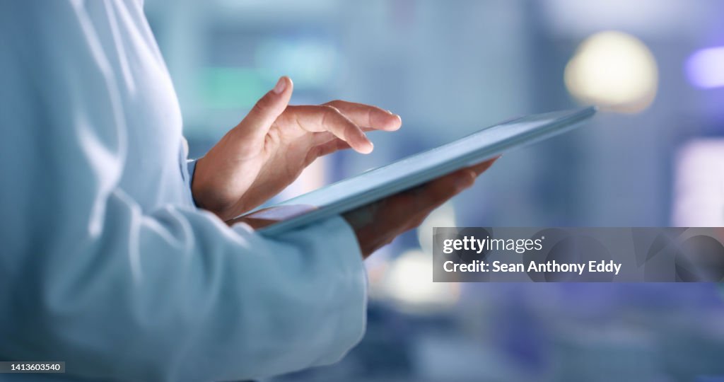 Médico, pesquisador ou cientista navegando na internet em um tablet para obter informações enquanto trabalhava em um laboratório, instalação científica ou hospital. Especialista, profissional médico ou cirurgião pesquisando na internet