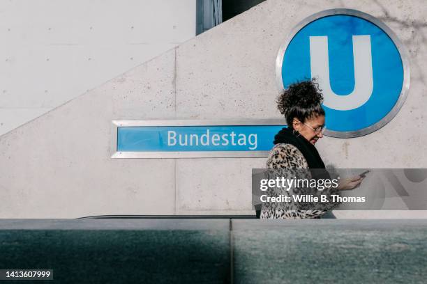 woman exiting ubahn using escalator - calling on the side road stock pictures, royalty-free photos & images