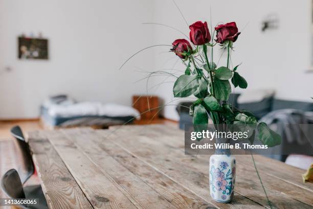 close up of vase and roses on living room table - table only close up stock-fotos und bilder