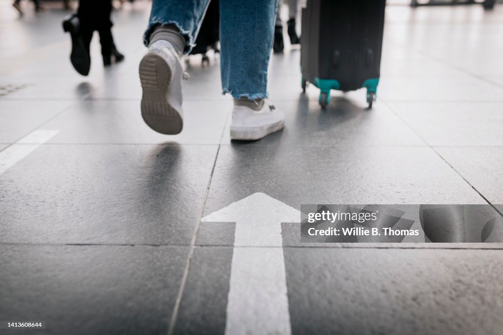 Close Up People Following Directions Displayed As Arrows On Floor