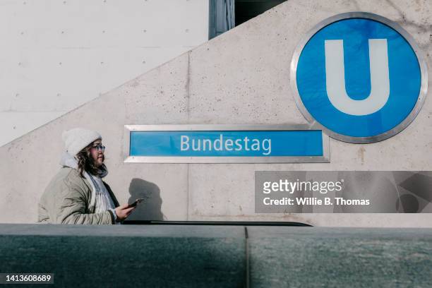 woman walking down ubahn escalator - letter u stock pictures, royalty-free photos & images