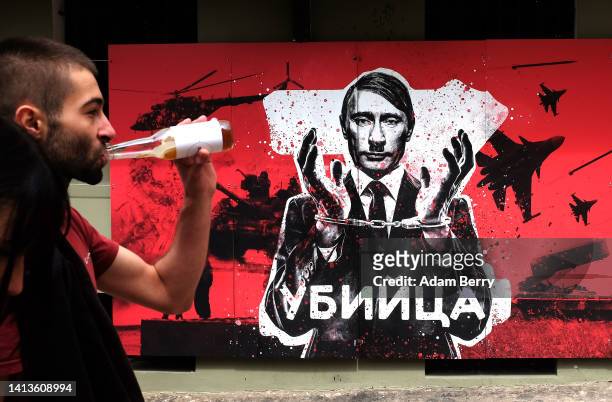Mural with the image of Russian President Vladimir Putin in handcuffs with a moustache and haircut evoking Adolf Hitler, above the word "Killer" in...