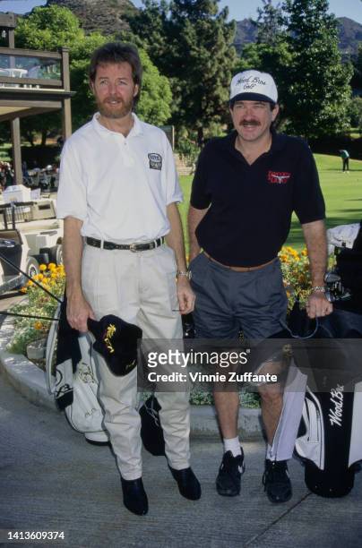 Ronnie Dunn and Kix Brooks in golfing attire pose with golf equipment, United States, circa 1994.