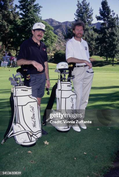 Kix Brooks and Ronnie Dunn lean on their bag of golf clubs during a game of golf, United States, circa 1994.