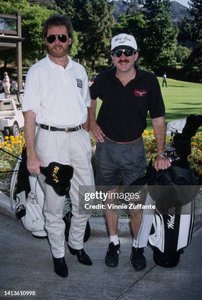 Ronnie Dunn and Kix Brooks in golfing attire pose with golf equipment, United States, circa 1994.