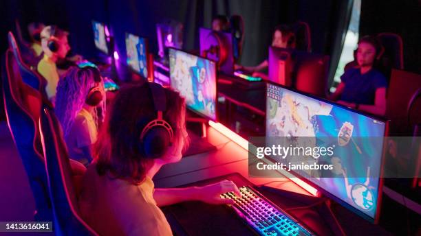 diverso equipo femenino de jugadores profesionales amarillos con líder de etnia africana que compite en el campeonato de esport de videojuegos. equipo azul en el otro lado - computer game fotografías e imágenes de stock