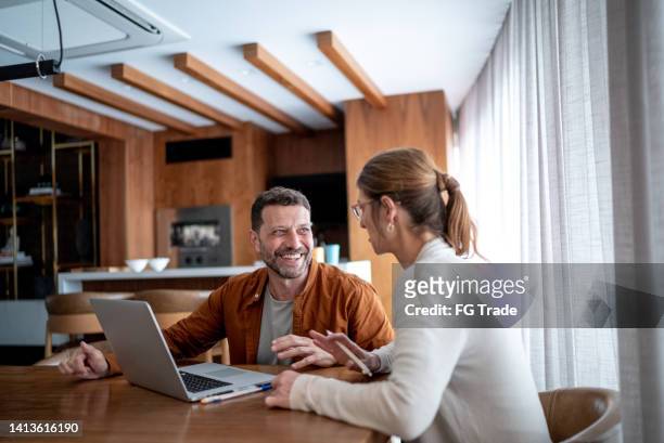 家でノートパソコンを話し、使う中高生夫婦 - x世代 ストックフォトと画像