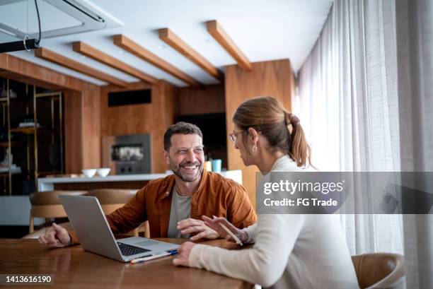 mature couple talking and using the laptop at home - financial planning home stock pictures, royalty-free photos & images