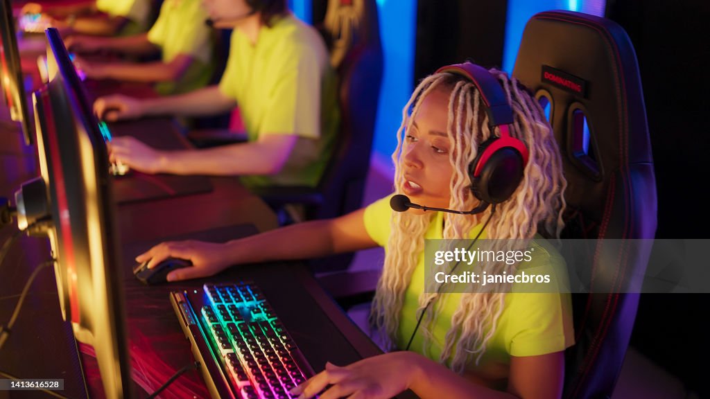 Diverse yellow pro gamer team with african ethnicity players competing at video game eSport championship